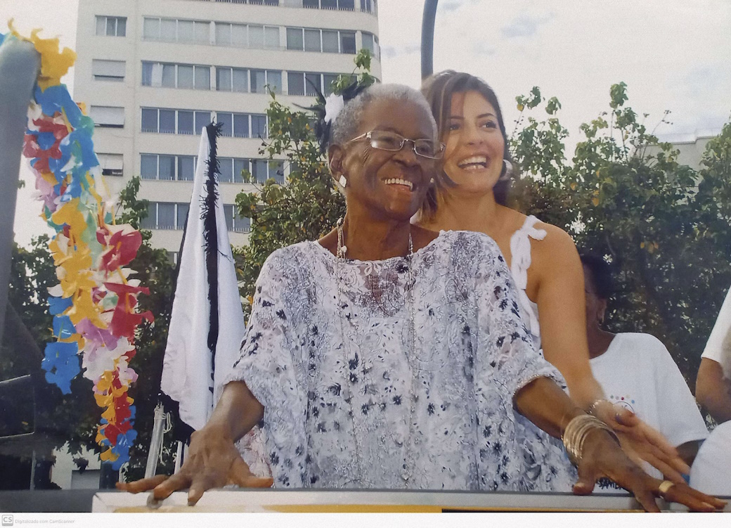 Sócia fundadora do Clube do Samba e assídua componente do bloco, Vó Maria não deixava de desfilar fizesse chuva ou sol.Vó Maria faz aniversário no mesmo dia do Clube do Samba -
05/05Na imagem

Vó Maria e Clarisse Nogueira - Filha de João Nogueira 